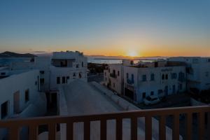 una vista su un tramonto da un balcone con edifici di El_Puerto Luxury port suites a Naxos Chora