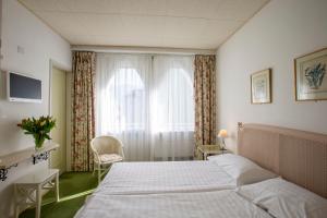 Un pat sau paturi într-o cameră la Piccolo Hotel