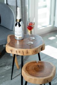 una bottiglia di vino e un bicchiere su un tavolo di legno di El_Puerto Luxury port suites a Naxos Chora