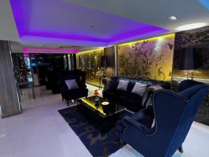 a living room with a couch and chairs and purple ceilings at iCheck inn Nana by Aspira in Bangkok