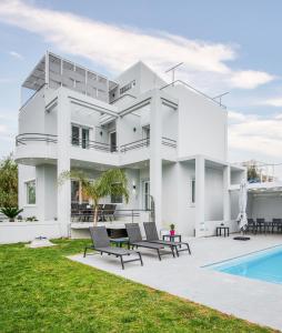 une maison blanche avec piscine et pelouse dans l'établissement Villa Giota, à La Canée