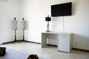 リド・デッリ・エステンシにあるDubaiBeachotelのデスク、壁掛けテレビが備わる客室です。