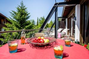 a table with a bowl of fruit and drinks on a balcony at Studio im Loft in Oberstdorf