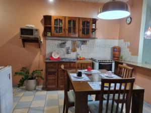 a kitchen with a wooden table and a table and chairs at Casa 170 in Belém