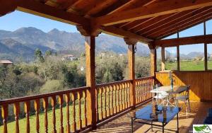 een veranda met een tafel en uitzicht op de bergen bij Casa Vacacional Mari Paz in Llanes