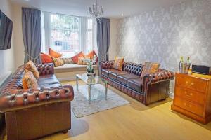 a living room with leather couches and a table at Scarborough Stays - Luxury Townhouse Ideal for large groups - HOT TUB in Scarborough