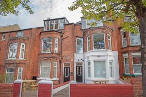 a red brick building with a table in front of it at Scarborough Stays - Luxury Townhouse Ideal for large groups - HOT TUB in Scarborough
