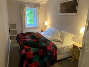 a bedroom with a bed with a quilt on it at Devon Country Paradise in Tavistock