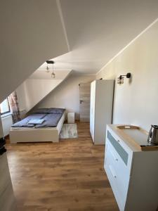 een kleine kamer met een bed en een koelkast bij Zatoka Stegna in Stegna