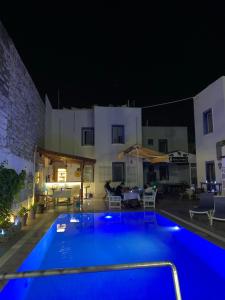 a swimming pool in front of a building at night at Kılavuz otel in Bodrum City