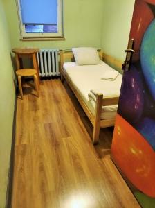a small bedroom with a bed and a chair at Jopi Hostel Katowice Centrum in Katowice