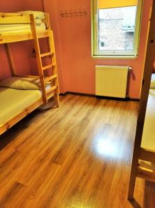 a room with two bunk beds and a wooden floor at Jopi Hostel Katowice Centrum in Katowice