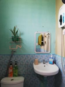Un baño con lavabo, inodoro y espejo. en Agimats Crib Palawan, en Puerto Princesa City