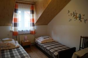 um quarto com 2 camas e uma janela em Ostoja em Polańczyk