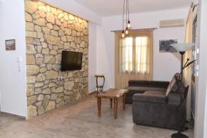 a living room with a couch and a stone wall at Casa Galini in Kalamata