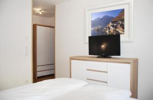ein Schlafzimmer mit einem Bett und einem TV auf einer Kommode in der Unterkunft Panorama Appartement 1 in Mauterndorf