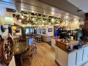 a restaurant with a bar and a table and chairs at Garddfon Inn in Y Felinheli