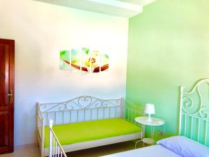 Un dormitorio con una cama verde y una mesa en Apartment Maria en Tergu