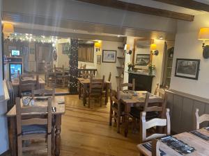 a restaurant with wooden tables and chairs in a room at Garddfon Inn in Y Felinheli