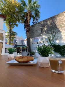 einen Tisch mit einem Teller Essen und einem Getränk in der Unterkunft Kılavuz otel in Bodrum City