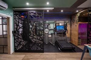 a gym with a treadmill in a room at Capsule Wellness - sauna - balneo - machine de sport privatif - PS5 - 2 chambres in Valenciennes
