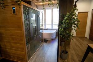 a bathroom with a tub and a large window at Capsule Wellness - sauna - balneo - machine de sport privatif - PS5 - 2 chambres in Valenciennes