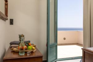 a table with a bowl of fruit and a glass bottle at Ligaridia Apartments in Moutsoúna