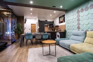 a living room with a couch and a table at Capsule Wellness - sauna - balneo - machine de sport privatif - PS5 - 2 chambres in Valenciennes