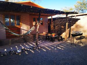 a patio of a house with a table and a grill at CABAÑA SAN PEDRINA in San Pedro de Atacama