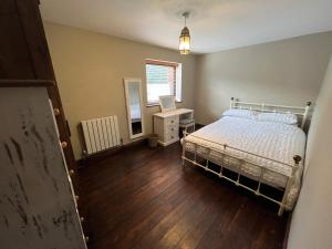 um quarto com uma cama, uma secretária e uma janela em Modern upside down property with hot tub em Roughton