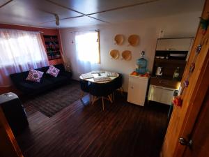 a living room with a couch and a small kitchen at CABAÑA SAN PEDRINA in San Pedro de Atacama