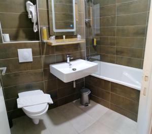 a bathroom with a sink and a toilet and a mirror at La Buissonnière in Corbigny