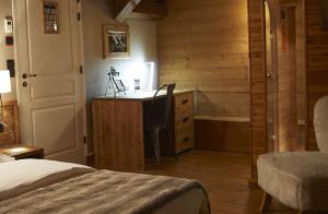 a bedroom with a bed and a desk with a chair at Le Moulin de Lily in Palaiseau