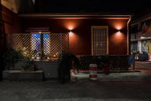 ミラノにあるホテル セブン ルームスの塀を前に夜の家