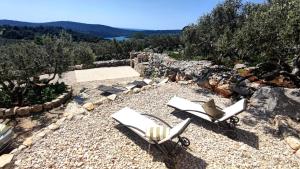 two white chairs sitting on top of a hill at Luxury stone house in a Nature park in Sali