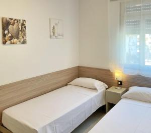 a bedroom with two beds and a window at Villa Ivona in Bibione