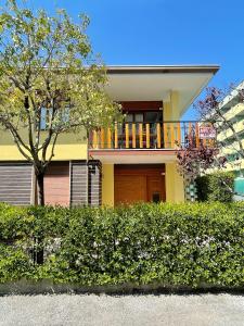 una casa con balcone in cima a una siepe di Villa Ivona a Bibione