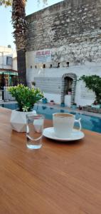 una taza de café y un vaso de agua sobre una mesa en Kılavuz otel en Bodrum