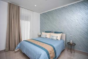 1 dormitorio con 1 cama grande con sábanas y almohadas azules en Charme en Bleu en Castellammare di Stabia