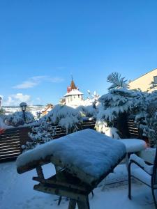 un banco cubierto de nieve frente a un edificio en Ferien-Sempachersee Sandra Sens en Sempach