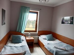 a bedroom with two beds and a window at Zajazd Stary Młyn in Świdwin