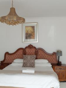 a bed with a wooden headboard in a bedroom at Naleli Guest House in Selomas +12 photos