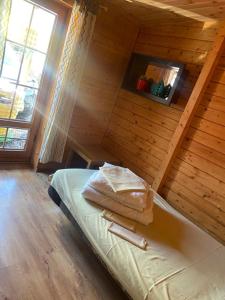 ein Schlafzimmer mit einem Bett in einer Holzhütte in der Unterkunft Domki Drewniane Całoroczne in Krynica Morska