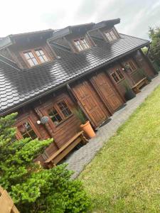 a wooden house with wooden doors and windows at Domki Drewniane Całoroczne in Krynica Morska