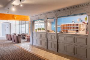 a room with a salon with chairs and a counter at Hôtel Akena Poitiers Nord Futuroscope in Chasseneuil-du-Poitou