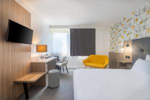 a hotel room with a bed and a desk and chair at Hôtel Akena Poitiers Nord Futuroscope in Chasseneuil-du-Poitou