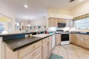 a large kitchen with wooden cabinets and a sink at 4954 Summer Beach Blvd in Fernandina Beach