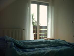 Cama en habitación con ventana en Apartments Maja, en Bled
