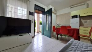 a kitchen with a tv and a table with red chairs at Fiorilli House - Fair District - Gratis Private Parking in Bologna