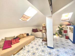 uma sala de estar com um sofá com almofadas em JOY BAMBOO, Downtown, three min from the Sea em Bogliasco